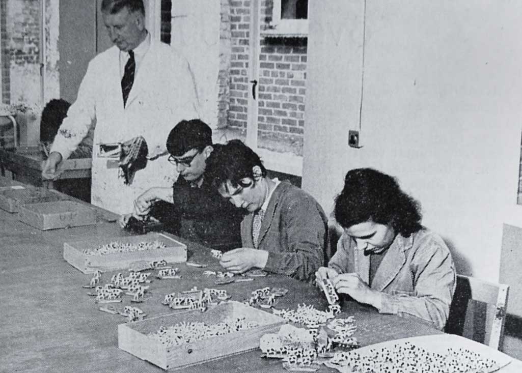 Mr H. McKelvie, The Works Manager, at the head of an assembly line in the production of toy sets, by Richard Lewis, Joan Hubbard and Ann Rogers, a contract undertaken for Mettoys Ltd.